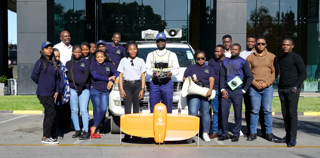 The Zambia survey team outside their office with the vehicle and the fixed-wing UAV used to fly imagery